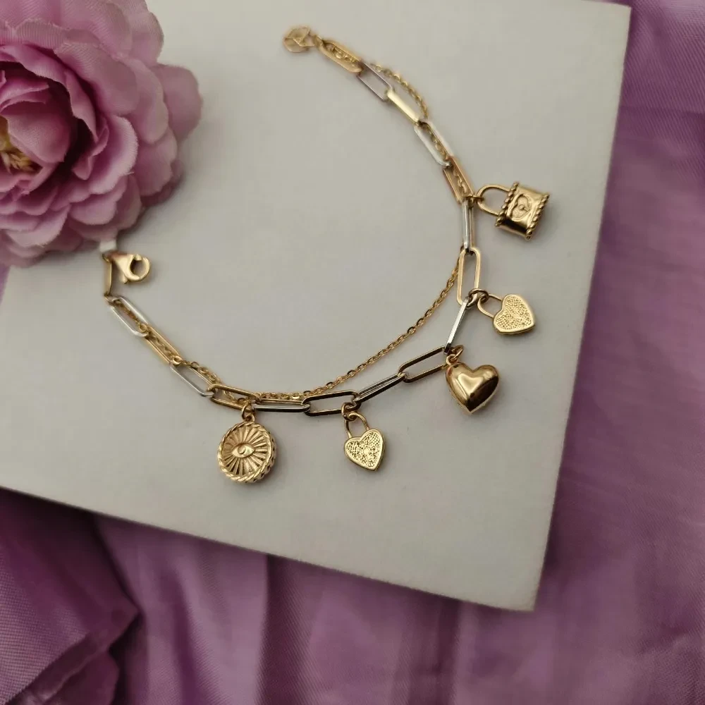 Crafted in 18K HUID Hallmarked Gold, the Charms of Love Gold Bracelet from Swastik Jewellers is a stylish expression of individuality, featuring a contemporary chain-link design accented with charming dangling motifs. The bracelet combines polished gold links with subtle two-tone detailing, creating a modern layered look, while the centre
